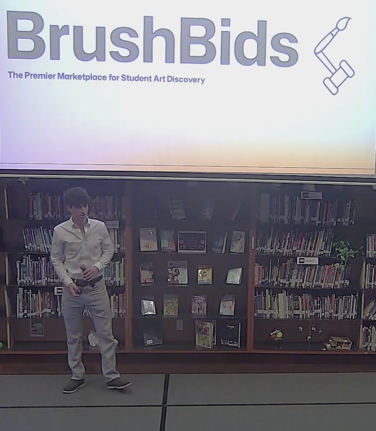 Charles Greenwald presenting BrushBids in front of the title slide at the Dwight School library