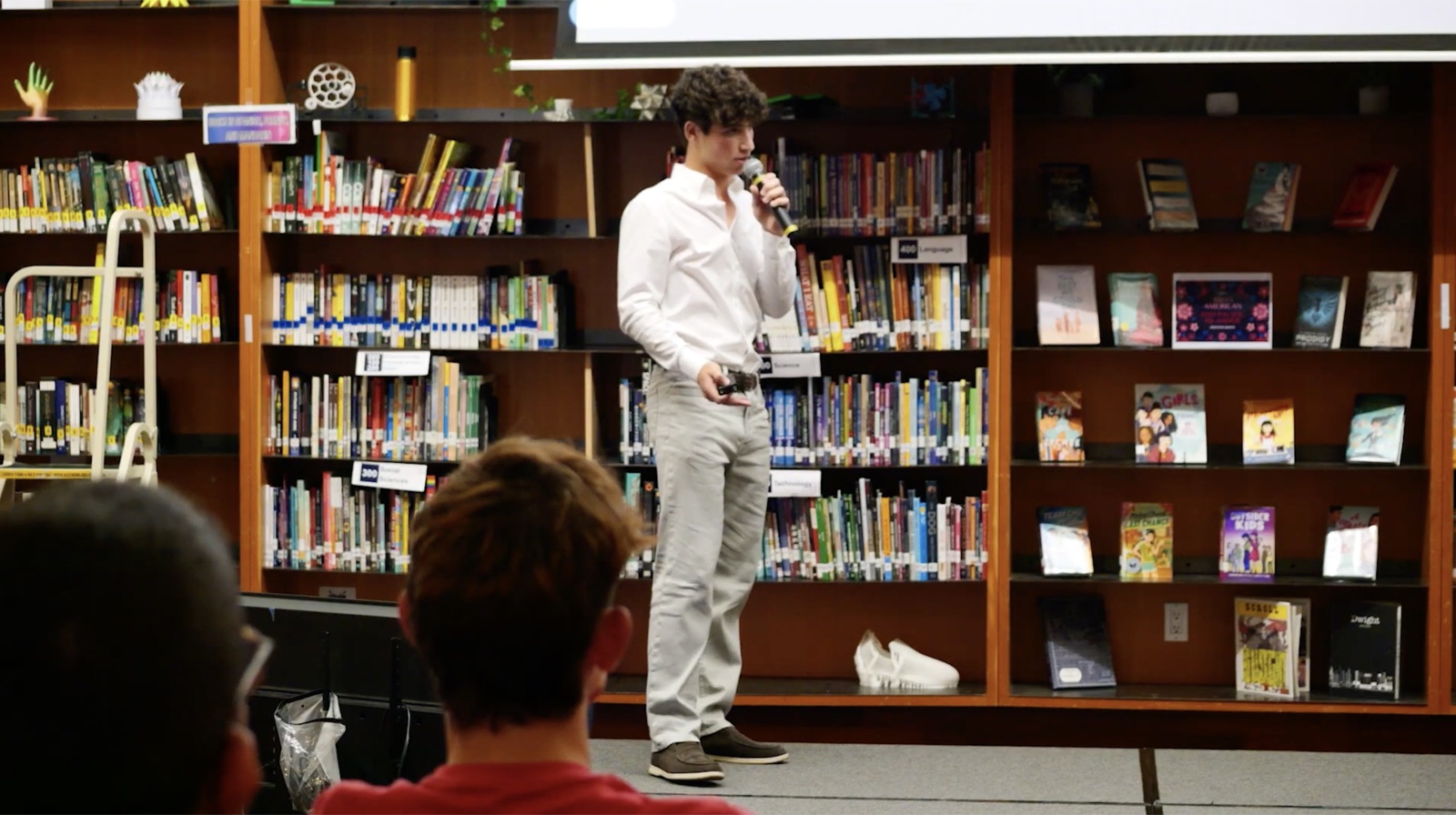Charles Greenwald presenting to a seated audience in a school library
